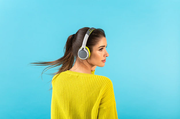 man-listening-music-wireless-headphones-happy-wearing-yellow-knitted-sweater-blue_285396-10518